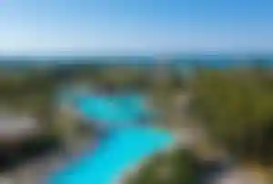 Lara Barut Collection – Luxus Hotel an der türkischen Riviera Große Poollandschaft mit Palmen und Blick auf das Meer in der Lara Barut Collection an der türkischen Riviera