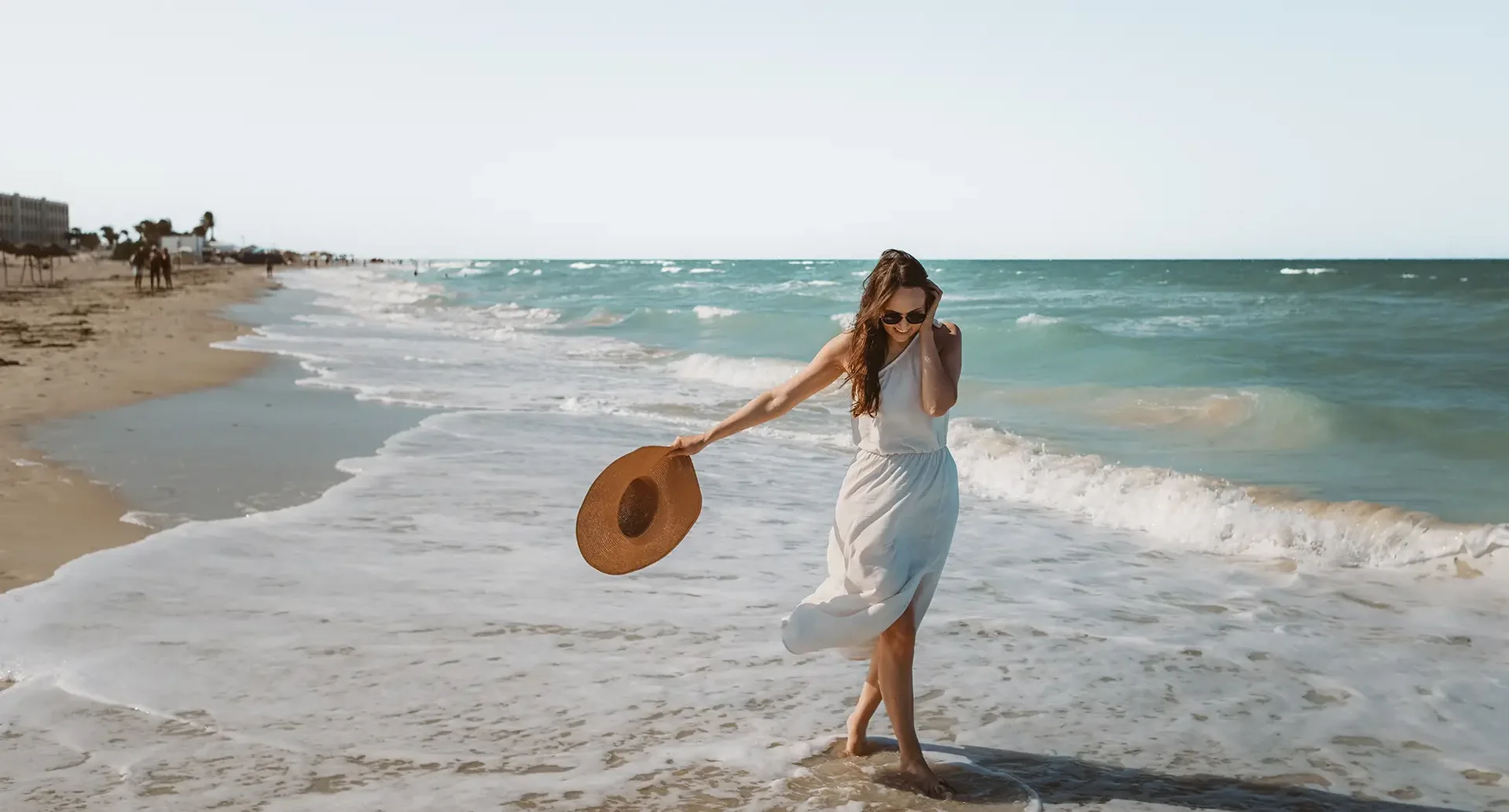 Strandszene in Djerba Tunesien Person in heller Kleidung am Strand von Djerba mit Blick auf das Meer