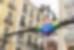 Metro-Eingang im Madrider Viertel Chueca mit Regenbogenfarben und historischen Gebäuden im Hintergrund