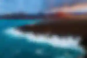 Vulkanlandschaft und Felsküste auf Lanzarote mit Atlantikwellen, beliebtes Reiseziel für Last Minute Urlaub auf den Kanaren
