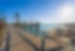 Holzsteg an einem Strand in Hurghada mit türkisblauem Wasser und Sonnenschein am Roten Meer