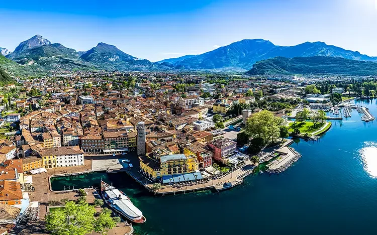 Luftaufnahme von Riva del Garda mit Hafen, Altstadt und Bergen rund um den Gardasee