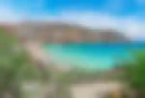 Bucht am Super Paradise Beach auf Mykonos mit türkisfarbenem Wasser und Küstenlandschaft