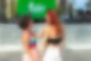 Zwei Personen stehen vor einer Bühne beim Barcelona Pride Festival und halten sich an den Händen