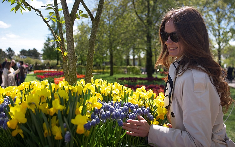 Dame im Keukenhof bei gelben Frühlingsblumen