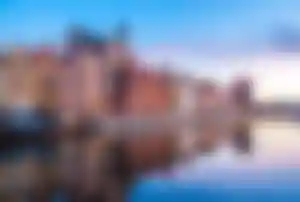 Historische Altstadt mit farbenfrohen Häusern und Flusspromenade in einer osteuropäischen Stadt