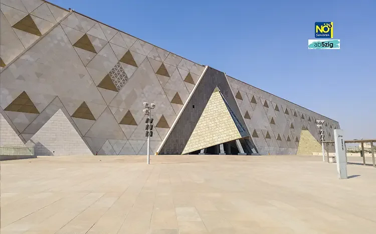 Moderne Außenansicht des Grand Egyptian Museum in Gizeh mit geometrischer Architektur.