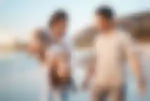 Drei Menschen verbringen gemeinsam Zeit an einem Sandstrand am Meer während eines Urlaubs