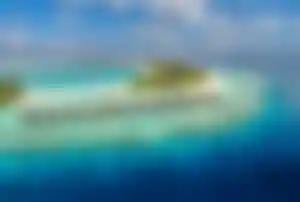 Person beim Schnorcheln neben einer Meeresschildkröte im kristallklaren Wasser der Malediven – beliebte Aktivität im Weihnachtsurlaub im Indischen Ozean.