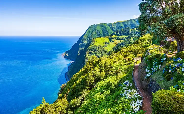 Aussichtspunkt Ponta do Sossego mit üppiger Vegetation, Blumen und Blick auf die Steilküste von São Miguel.