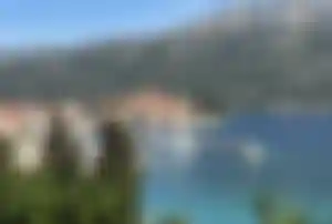 Altstadt von Korčula in Kroatien mit Hafen, Segelbooten und Bergen im Hintergrund
