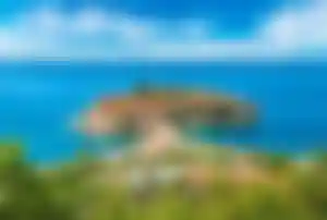Kleine Küsteninsel mit historischen Gebäuden im türkisblauen Meer vor der Adriaküste Montenegros