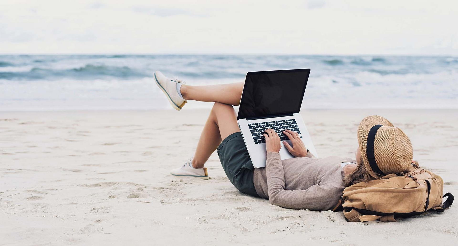 Frau am Meer mit Laptop 