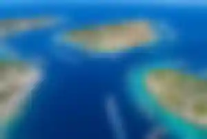 Türkische Ägäis mit türkisblauem Meer, kleinen Inseln und zahlreichen Booten in einer Badebucht