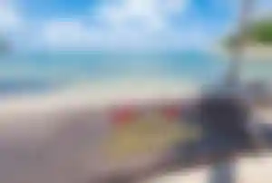 Schriftzur Merry Christmas auf einer Schaukel an einem tropischen Strand