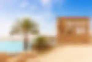 Historischer Tempel mit Palmen am Nilufer in Ägypten unter blauem Himmel – beliebtes Reiseziel für einen Weihnachtsurlaub im Warmen.