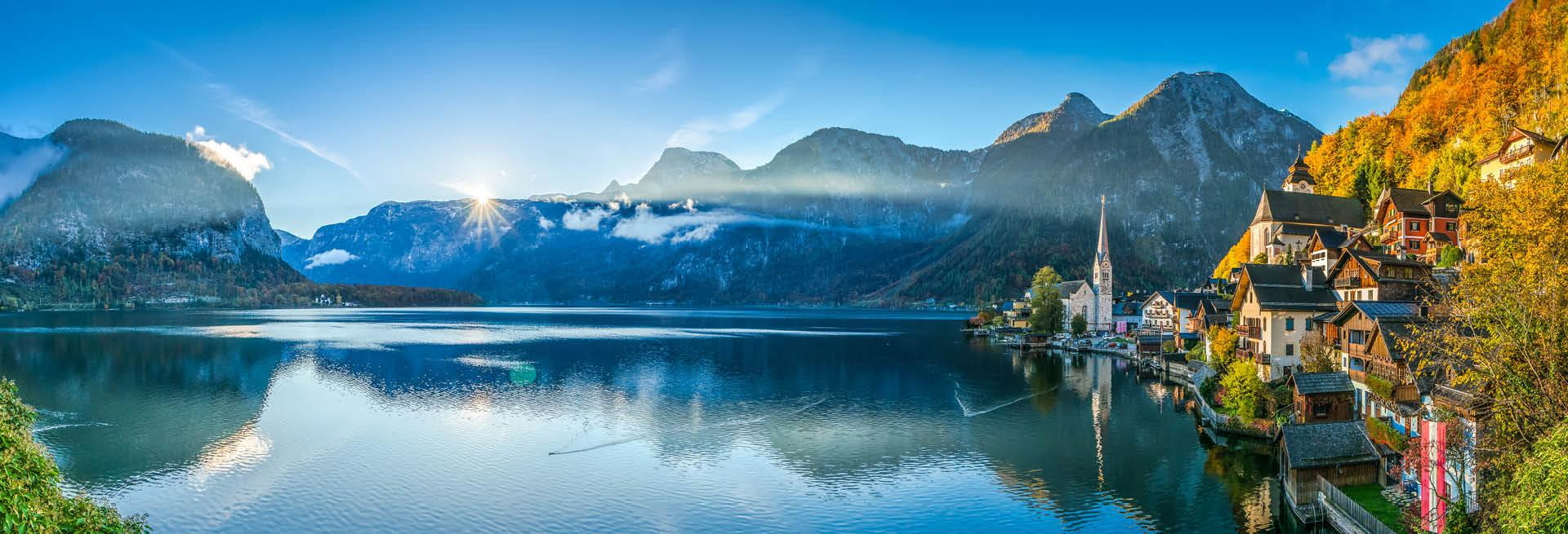 Herbsturlaub in Österreich: Hallstatt am See mit Alpenpanorama Panoramablick auf Hallstatt am Hallstätter See in den österreichischen Alpen mit bunten Herbstfarben, Bergen und Spiegelung im Wasser bei angenehmen Temperaturen