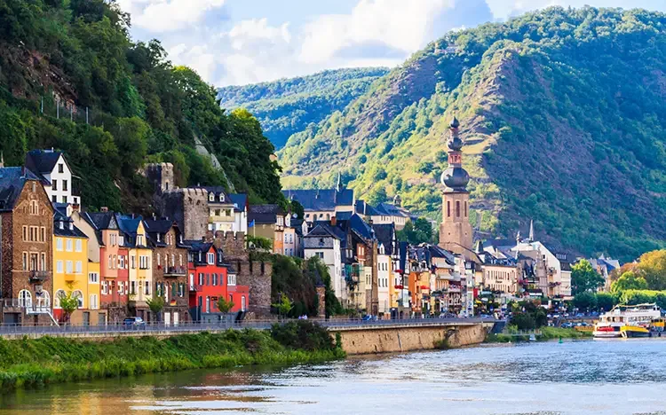 Bunte Fachwerkhäuser und Kirche entlang des Moselufers in Cochem