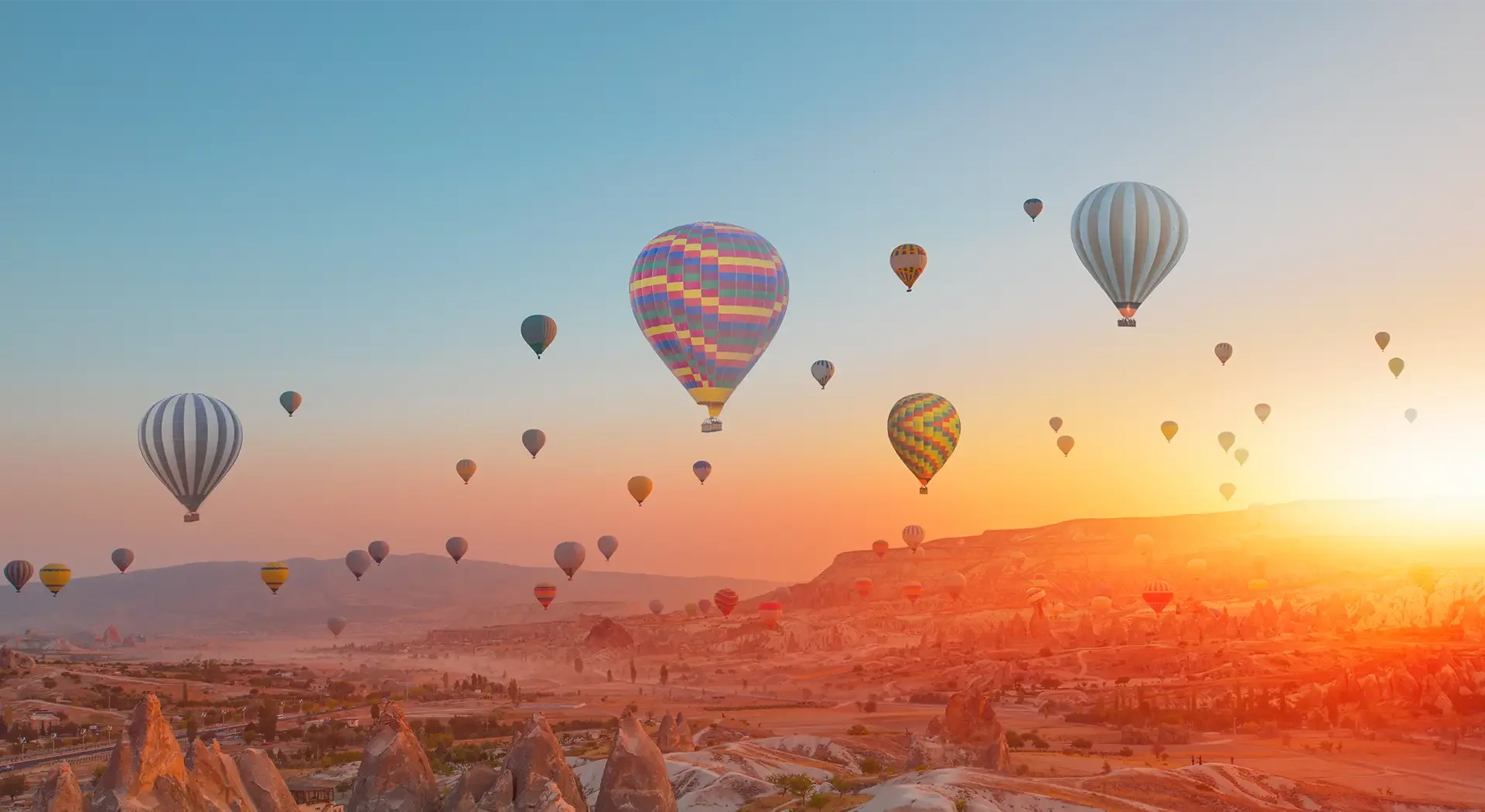 Heißluftballons über der Felsenlandschaft von Kappadokien bei Sonnenaufgang in der Türkei