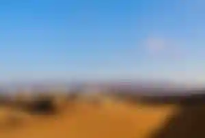 Dünenlandschaft von Maspalomas mit Sandwellen und Hotelanlagen im Hintergrund auf Gran Canaria