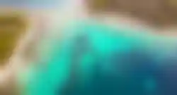 Luftaufnahme von türkisblauem Meer und kleiner Insel bei Brač Kroatien mit Badebuchten