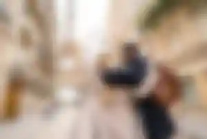 Romantische Städtereise Paris – Spaziergang zum Eiffelturm Zwei Personen spazieren in einer Pariser Straße mit Blick auf den Eiffelturm