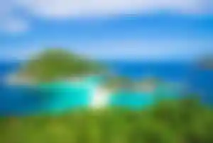 Tropische Insel Koh Tao in Thailand mit türkisblauem Meer, kleiner Sandbank und grüner Hügellandschaft aus der Vogelperspektive
