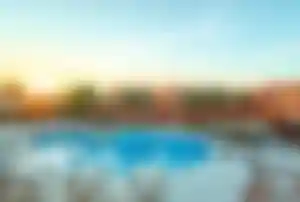 Poolanlage im TUI Blue Makadi in Hurghada mit Palmen, Cabanas und Hotelgebäuden bei Sonnenuntergang