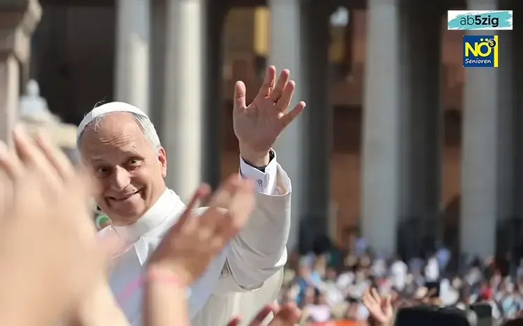 Papst Leo XIV. in weißer päpstlicher Kleidung winkt einer Menschenmenge auf dem Petersplatz, Hände von jubelnden Menschen im Vordergrund.