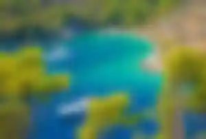 Idyllische Bucht in Kroatien mit Booten und smaragdgrünem Wasser umgeben von Pinien