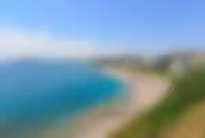Langer Sandstrand von Faliraki auf Rhodos mit Hotels, Liegen und Blick entlang der Küste