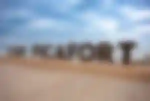 Großer Can Picafort Schriftzug an der Promenade mit Meer und bewölktem Himmel auf Mallorca