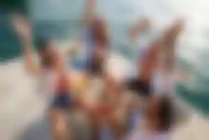 Gruppe feiert Partyurlaub mit Musik, Drinks und Tanz direkt am Meer