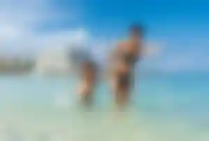 Mutter mit kleinem Sohn spielen im Meer auf Mallorca