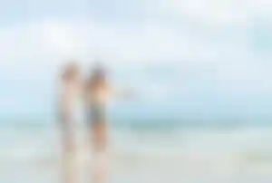 Zwei Personen verbringen gemeinsam Zeit am Strand von Mykonos mit Blick auf das Meer