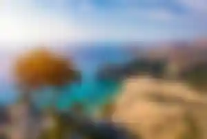 Panoramablick auf eine türkisfarbene Bucht mit Sandstrand, Felsenküste und Küstenlandschaft auf Rhodos