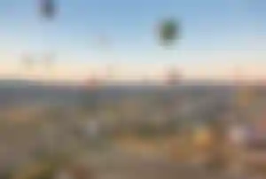 Heißluftballons steigen bei Sonnenaufgang über der Felslandschaft von Kappadokien