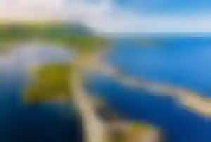 Luftaufnahme der Atlantikstraße in Norwegen mit Straße über Inseln, blauem Meer und grüner Küstenlandschaft