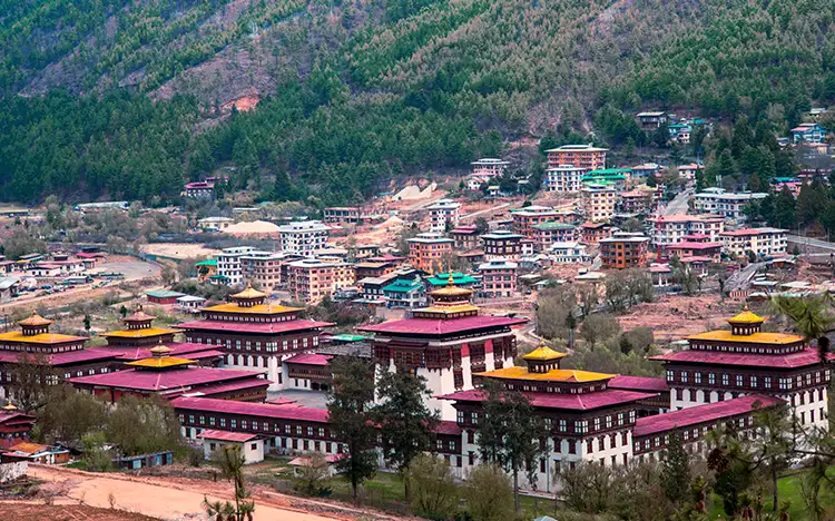 Panoramablick auf die Stadt Thimphu mit traditionellen Gebäuden und umliegenden Bergen in Bhutan