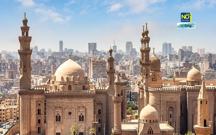 Blick auf die historische Altstadt von Kairo mit monumentalen Moscheen und moderner Skyline im Hintergrund.