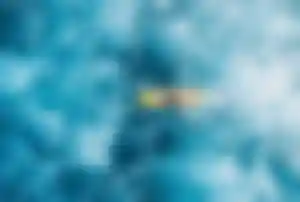 Surferin paddelt über türkisblaues Wasser