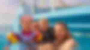 Badespaß für die ganze Familie auf der AIDAcosma Urlaubsgäste im Poolbereich mit Wasserrutsche an Bord der AIDAcosma
