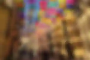 Bunte Regenschirme über einer Straße in Barcelona Bunte Regenschirme hängen über einer schmalen Straße mit historischen Gebäuden und Passanten in Barcelona