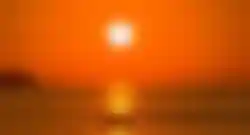 Sonnenuntergang über dem Meer in Kroatien mit Bootssilhouette auf dem Wasser