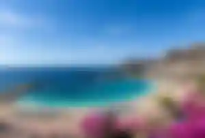 Playa de Amadores auf Gran Canaria mit türkisblauer Badebucht, Strandliegen und Promenade