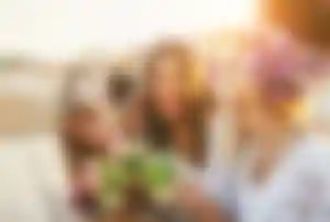 Freundesgruppe stößt mit Drinks in einer Strandbar während eines Partyurlaubs an