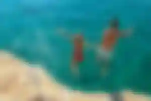 Aktiver Herbsturlaub: Klippenspringen in Kroatien Zwei Personen springen von einer Felsklippe in klares, blaues Meer in Kroatien – ideal für Aktivurlaub und Outdoor-Aktivitäten im Herbst