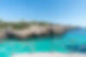 Felsküste und türkisblaues Meer an einer Bucht auf den Balearen in Spanien.