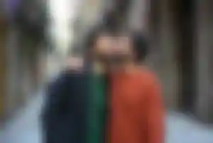 Zwei Personen spazieren gemeinsam durch eine historische Altstadt in Spanien