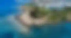 Zypern Hotels an der Küste – Hotelanlagen und Strände aus der Vogelperspektive Luftaufnahme einer Küstenlinie auf Zypern mit klarem Wasser, Hotelanlagen und grünen Gärten direkt am Meer